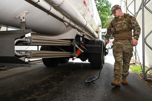 Image of Security forces Airman checking fuel truck