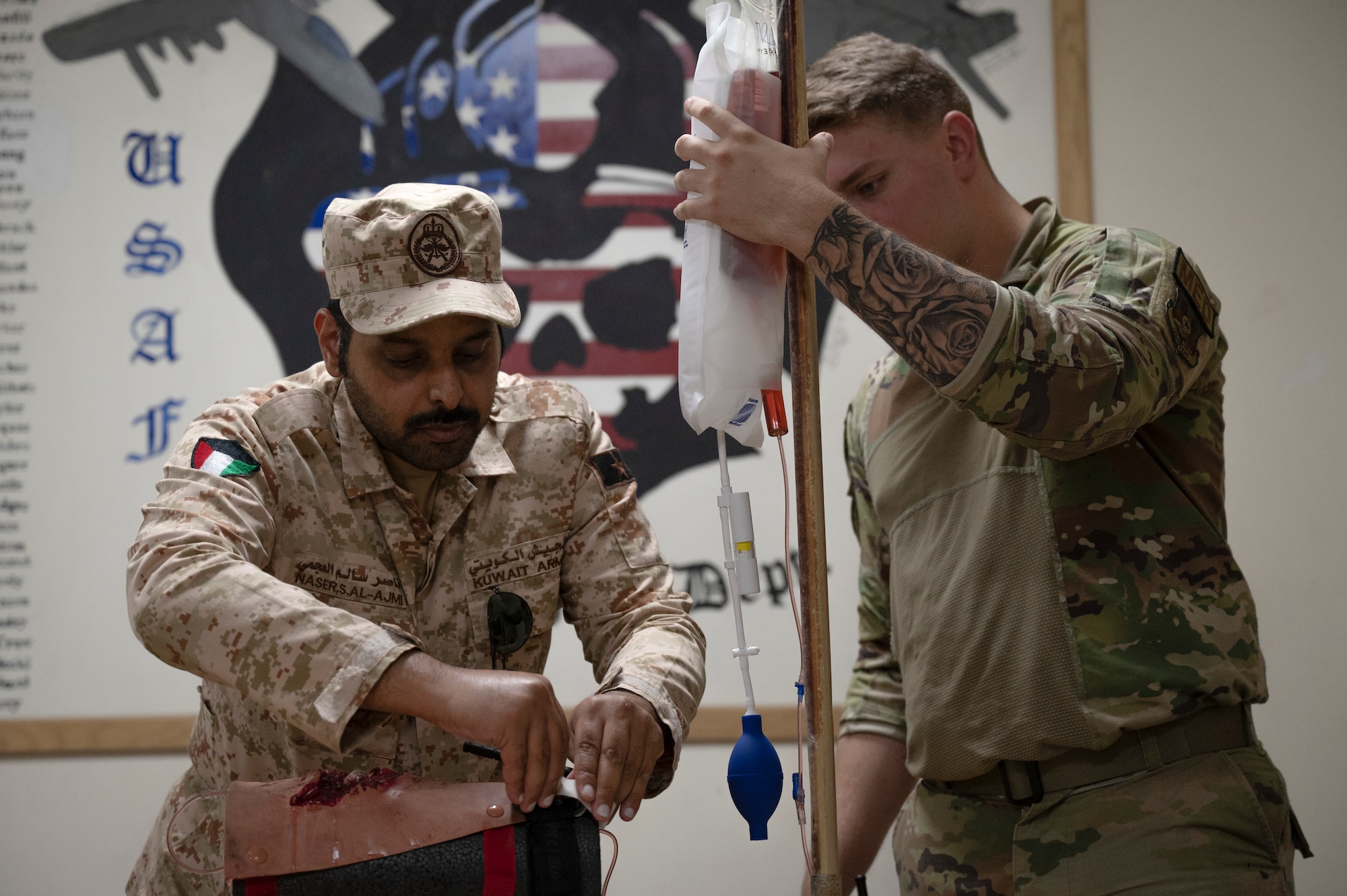 A Kuwait Army firefighter demonstrates how to properly apply a tourniquet to stop bleeding during a Tactical Combat Casualty Care class taught by Airman 1st Class Alex Moore, 386th Expeditionary Medical Squadron aerospace medical technician, September 14, 2022. Prior to the training, the 386th Expeditionary Civil Engineer Squadron fire department were able to craft a simulated, realistic and functioning injury for trainees to practice proper tourniquet application out of spare materials they had in the fire department. (U.S. Air Force photo by Staff Sgt. Dalton Williams)