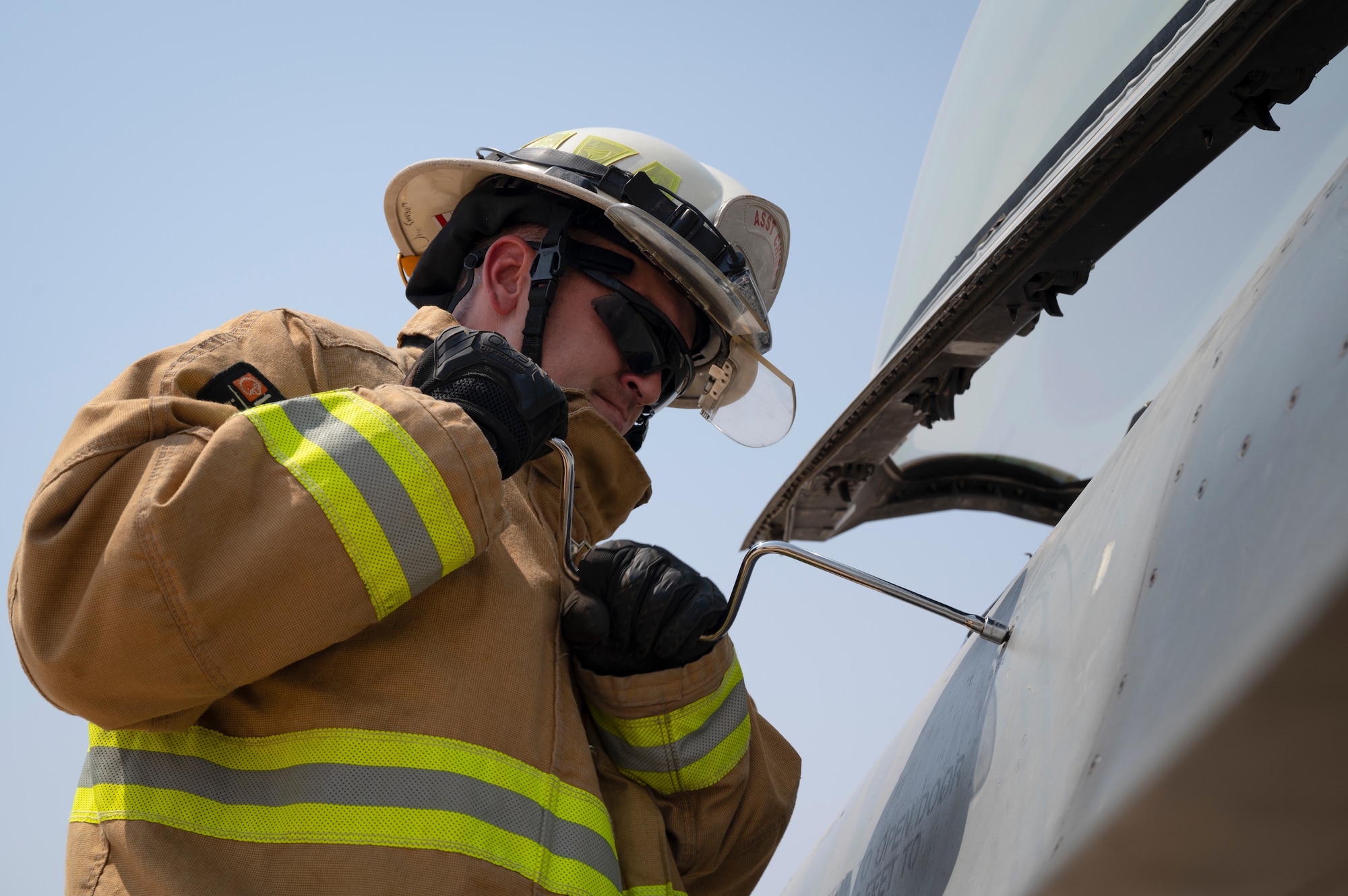 U.S. Air Force Tech. Sgt. Thomas Stewart, 386th Expeditionary Civil Engineer Squadron crew chief, opens the canopy with a speed wrench to an F-16CM Fighting Falcon during Operation Agile Spartan III, September 14, 2022. This exercise provided vital training to Kuwait Army firefighters and enabled smoother joint capacity response between coalition partners for future operations. (U.S. Air Force photo by Staff Sgt. Dalton Williams)