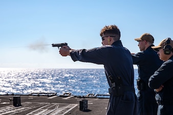 Fire Controlman (Aegis) 2nd Class Daniel Jacobs, assigned to the Ticonderoga-class guided-missile cruiser USS Leyte Gulf (CG 55), fires an M9 service pistol during a small arms gun shoot, Sept. 23, 2022.