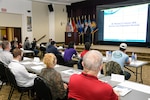 audience listens to speaker in auditorium