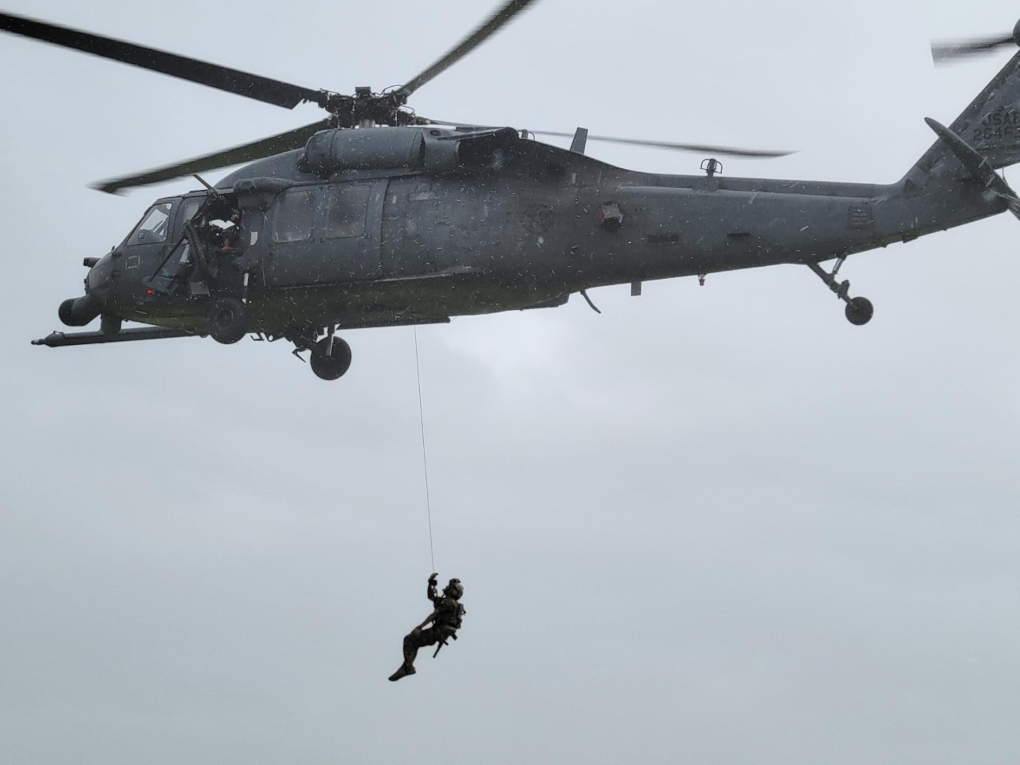 A person rappelling from a helicopter.