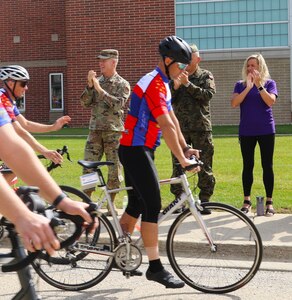Maj. Gen. Rich Neely, the adjutant general of Illinois and commander of the Illinois National Guard; Polish Gen. Cezary Wisniewski, deputy commander of the Polish Armed Forces, and Neely's spouse, Tammy, cheer on Gold Star 500 bicycle riders near North Chicago, Illinois, as they finish a 520-mile ride to raise awareness of the approximately 300 Illinois service members, including 34 in the Illinois National Guard, who have fallen since the 9/11 terrorist attacks. Illinois and Poland are partners under the State Partnership Program.