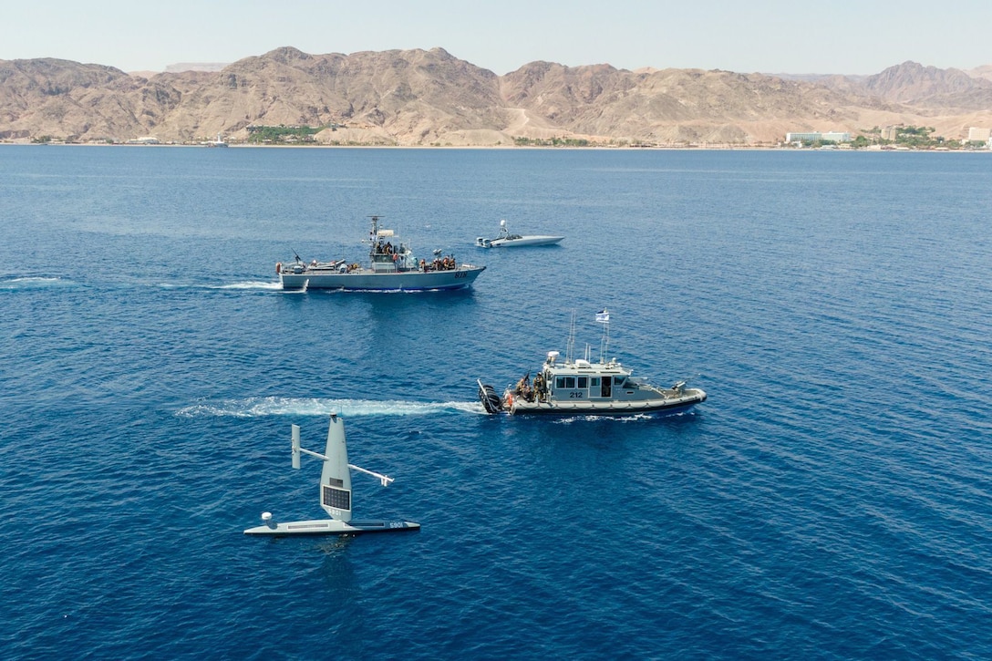 Four small boats sail next to each other.