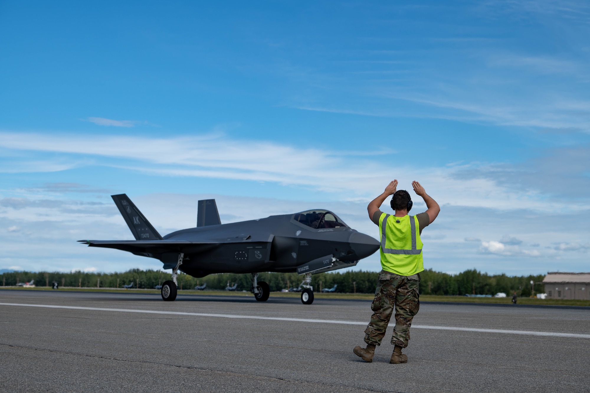 A maintainer signals an F-35A Lightning II on the flightline
