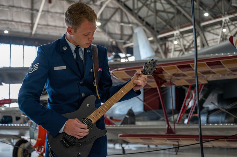 A military member plays a guitar.