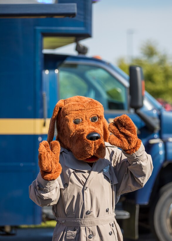 A person dressed up in a brown dog costume with a detective coat on.