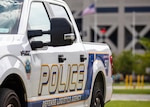 A white truck at a diagonal with police logos all over it.