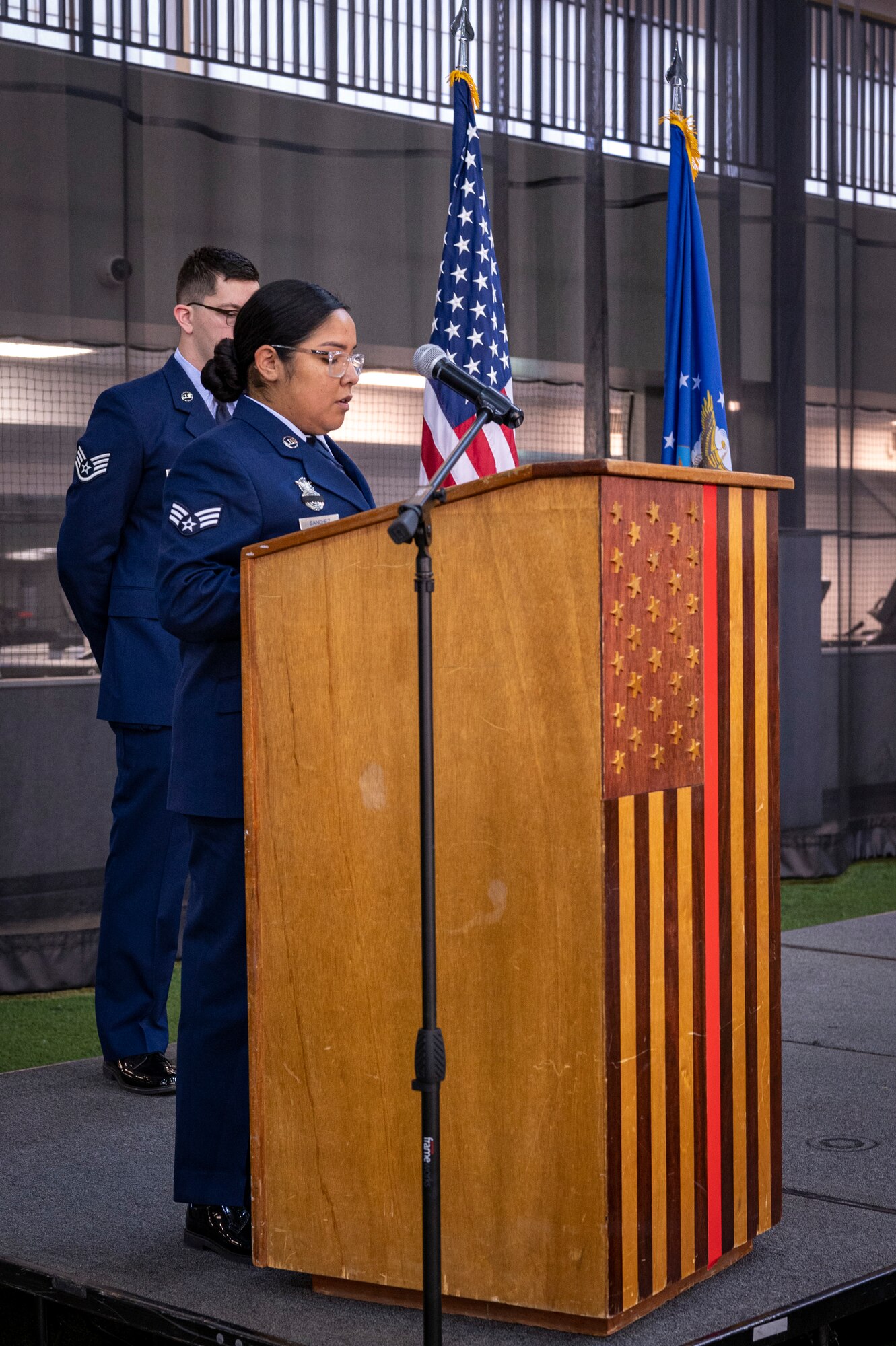 An airman reads a prayer during a ceremony