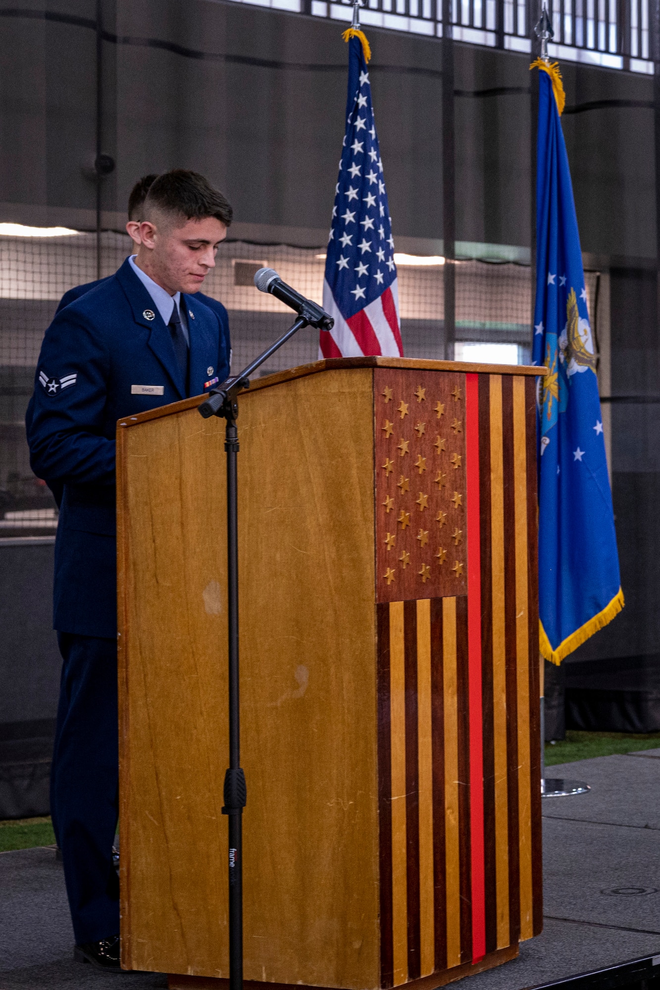 An airman reads a pray during a ceremony