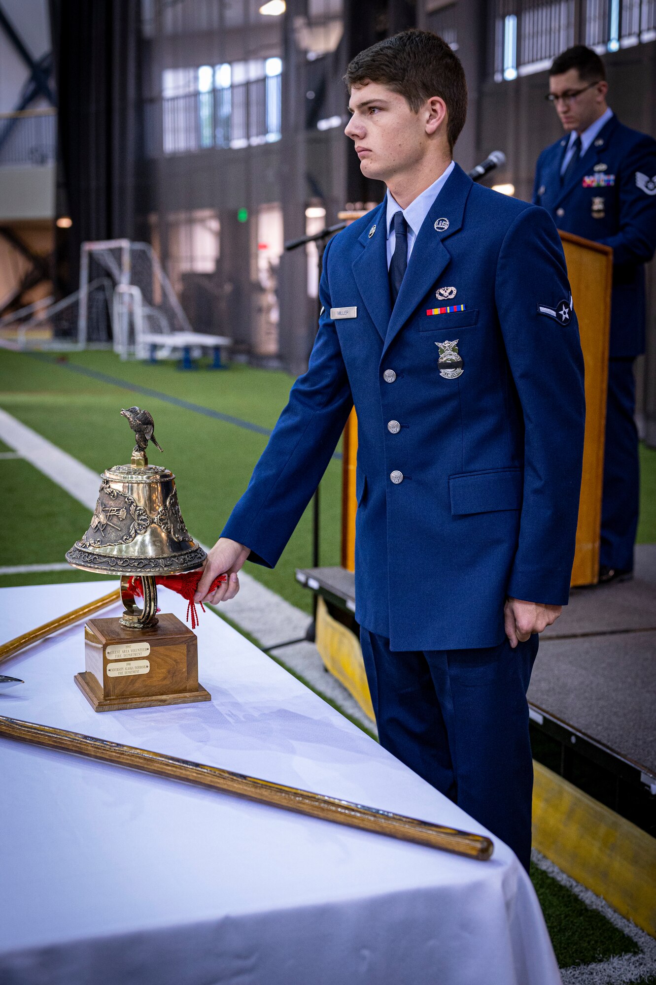 An airman tolls the bell during a ceremony