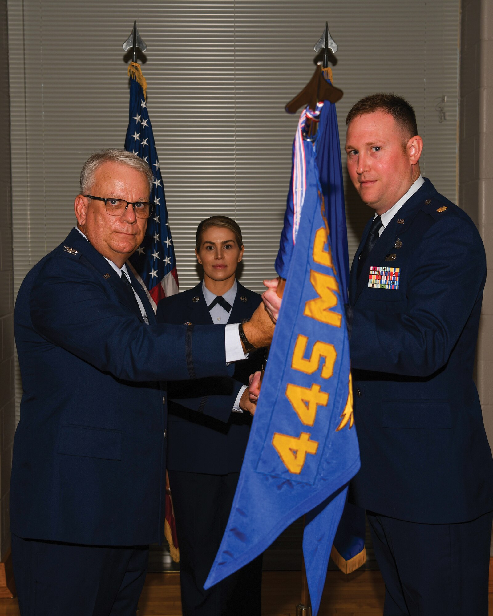 Col. Donald Wren, 445th Mission Support Group commander, passes the guidon to Maj. Michael Harrison, incoming 87th Aerial Port Squadron commander, during a change of command ceremony held at the Wright-Patterson Air Force Base United Service Organizations (USO) Center Sept. 9, 2022.