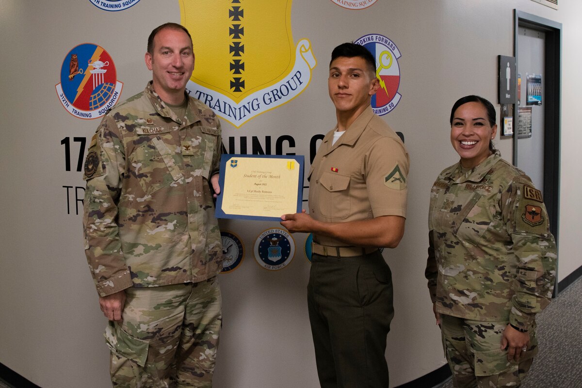 U.S. Air Force Col. Jason Kulchar, 17th Training Group commander, and Chief Master Sgt. Valerie Nededog, 17th TRG senior enlisted leader, present the 315th Training Squadron Student Leader of the Month award to U.S. Marine Corps Lance Cpl. Rudy Romero, Marine Corps Detachment Goodfellow student, at Goodfellow Air Force Base, Texas, September 26, 2022. Romero worked hard for his award and has shown his dedication to his detachment and the training he received at Goodfellow. (U.S. Air Force photo by Senior Airman Michael Bowman)