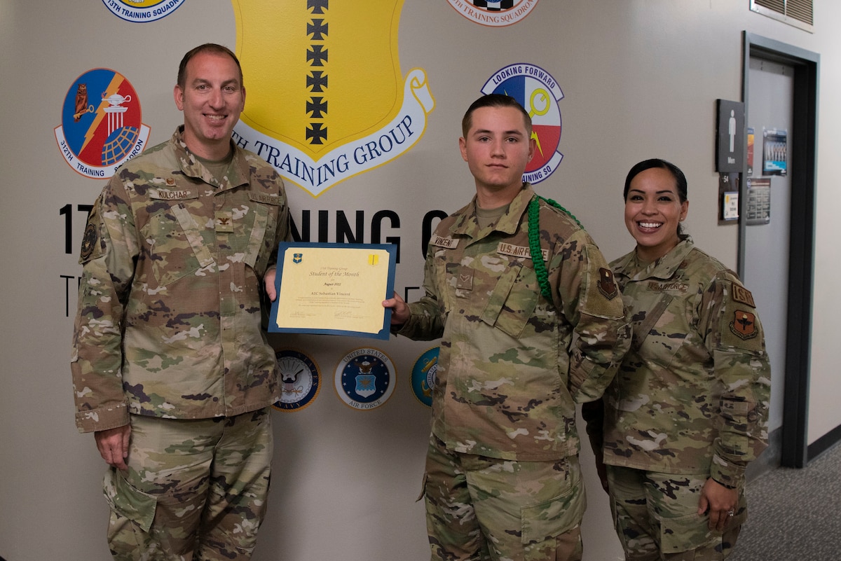 U.S. Air Force Col. Jason Kulchar, 17th Training Group commander, and Chief Master Sgt. Valerie Nededog, 17th TRG senior enlisted leader, present the 315th Training Squadron Student Leader of the Month award to Airman 1st Class Sebastian Vincent, 315th Training Squadron student, at Goodfellow Air Force Base, Texas, September 26, 2022. Vincent worked hard for his award and has shown his dedication to his squadron and the training he received at Goodfellow. (U.S. Air Force photo by Senior Airman Michael Bowman)