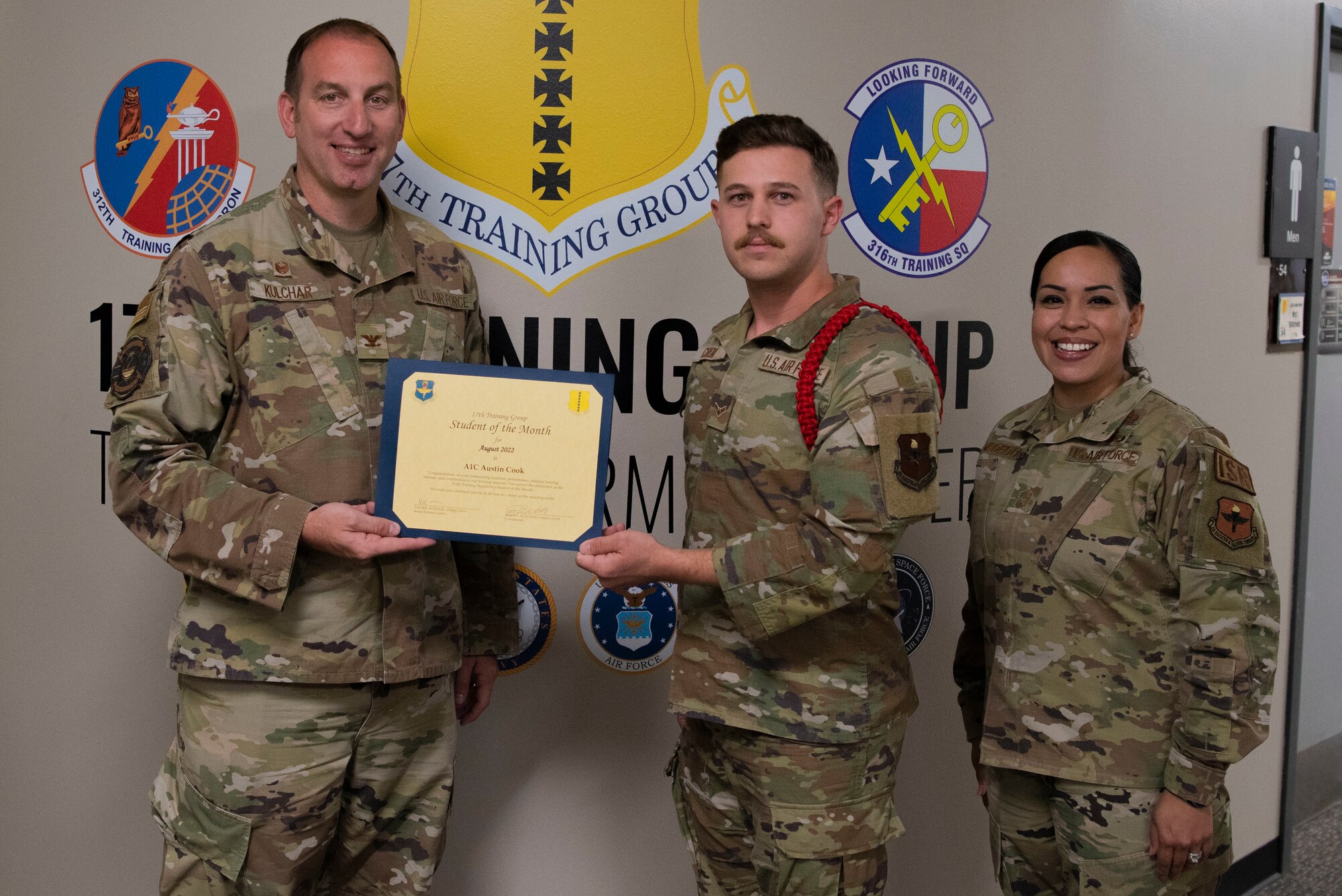 U.S. Air Force Col. Jason Kulchar, 17th Training Group commander, and Chief Master Sgt. Valerie Nededog, 17th TRG senior enlisted leader, present the 315th Training Squadron Student Leader of the Month award to Airman 1st Class Austin Cook, 315th Training Squadron student, at Goodfellow Air Force Base, Texas, September 26, 2022. Cook worked hard for his award and has shown his dedication to his squadron and the training he received at Goodfellow. (U.S. Air Force photo by Senior Airman Michael Bowman)