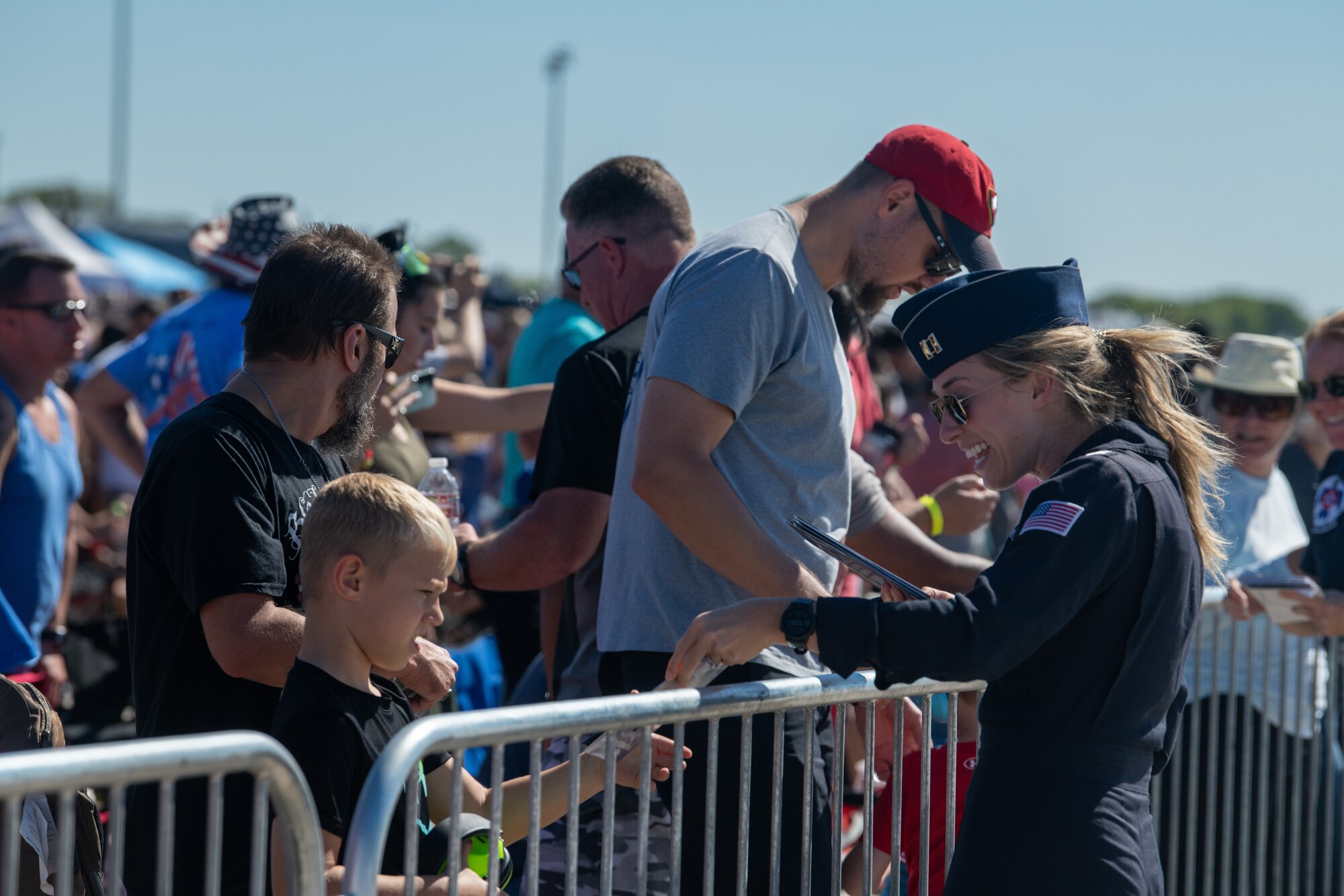 Capt. Kaitlin Toner, U.S Air Force Thunderbird Public Affairs Officer, hands out brochures to spectators at Frontiers in Flight Open House & Air Show, Sept. 25, 2022, McConnell Air Force Base, Kan.
