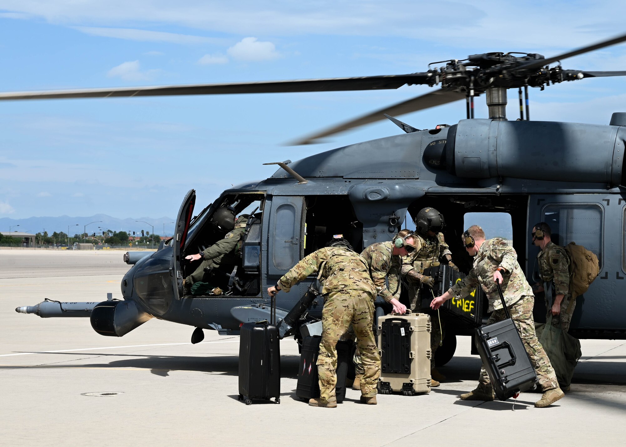 A photo of people loading boxes onto a helicopter.