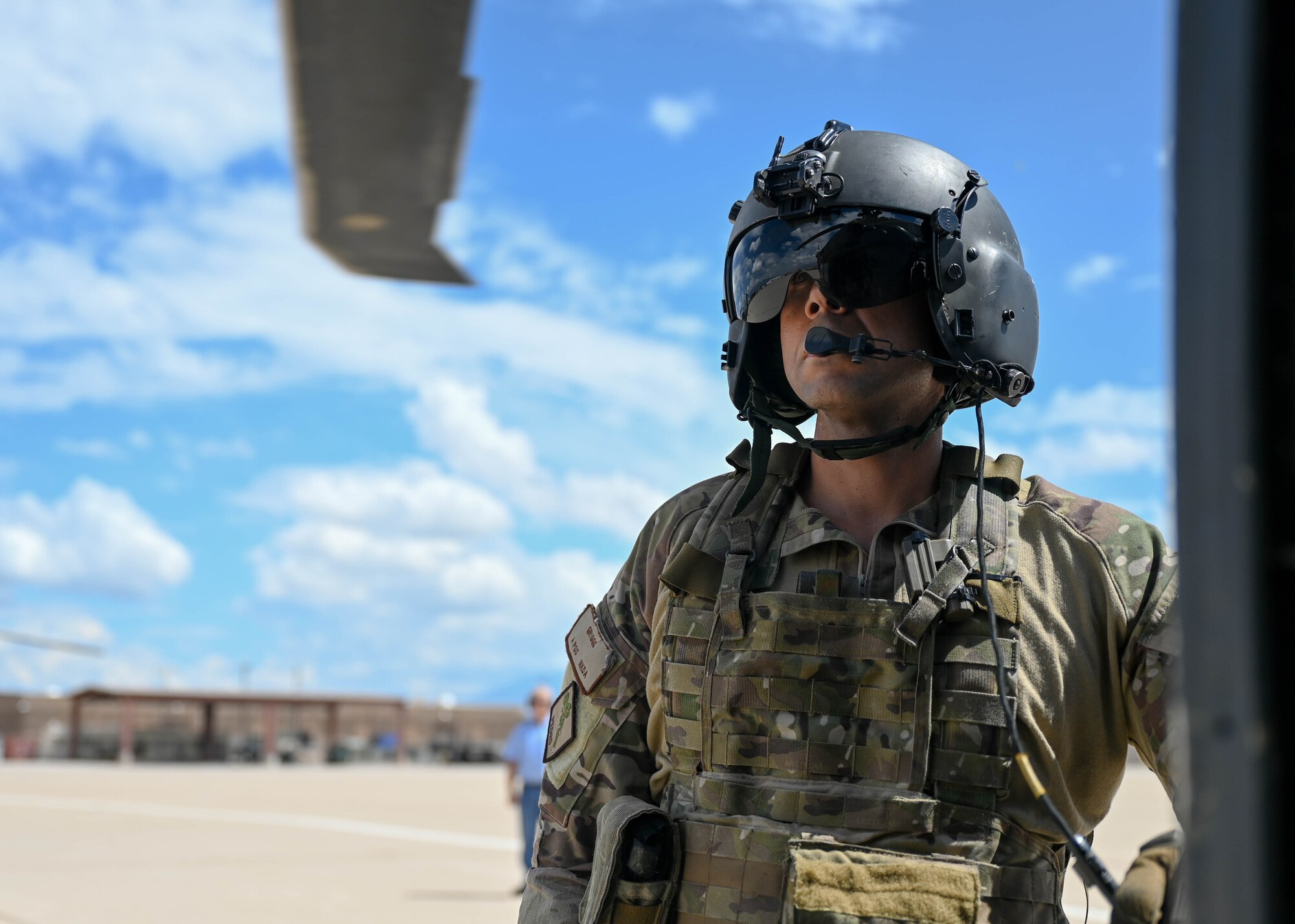 A photo of a man standing next to a helicopter.