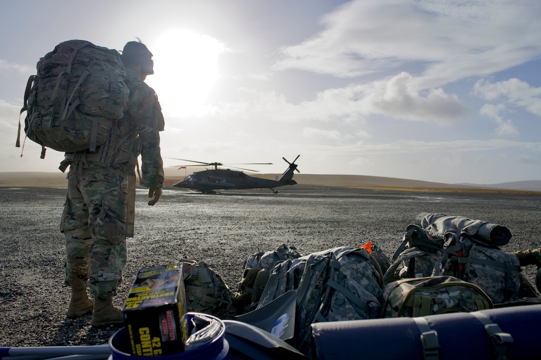 Alaska Army National Guard Spc. Tristan John, from Kwigillingok and an infantryman with B Company, 1st Battalion, 297th Infantry Regiment, travels to Tununak via a UH-60L Black Hawk helicopter assigned to A Company, 1st Battalion, 168th Aviation Regiment, to assist in site assessment and debris cleanup as part of Operation Merbok Response, Sept. 22, 2022. More than 130 members of the Alaska Organized Militia, which includes members of the Alaska National Guard, Alaska State Defense Force and Alaska Naval Militia, were activated following a disaster declaration issued Sept. 17 after the remnants of Typhoon Merbok caused dramatic flooding across more than 1,000 miles of Alaskan coastline. (Alaska National Guard photo by Staff Sgt. Kelly Willett)