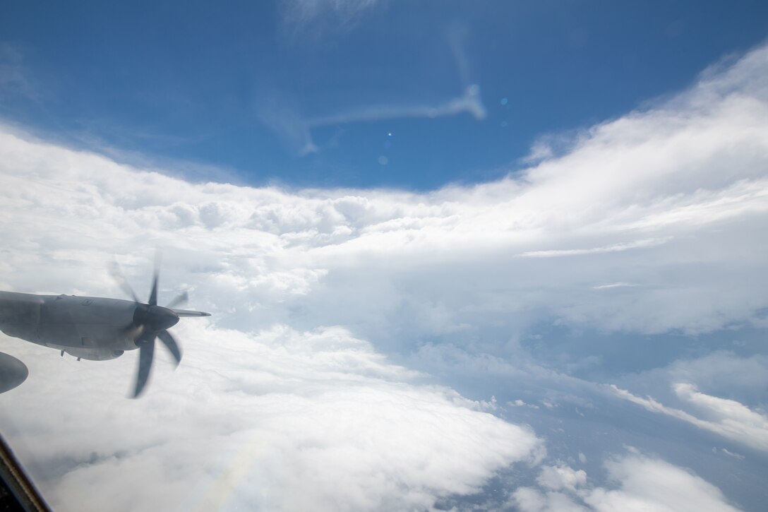 An aircraft's propeller is seen to the left of clouds in the eye of a hurricane.