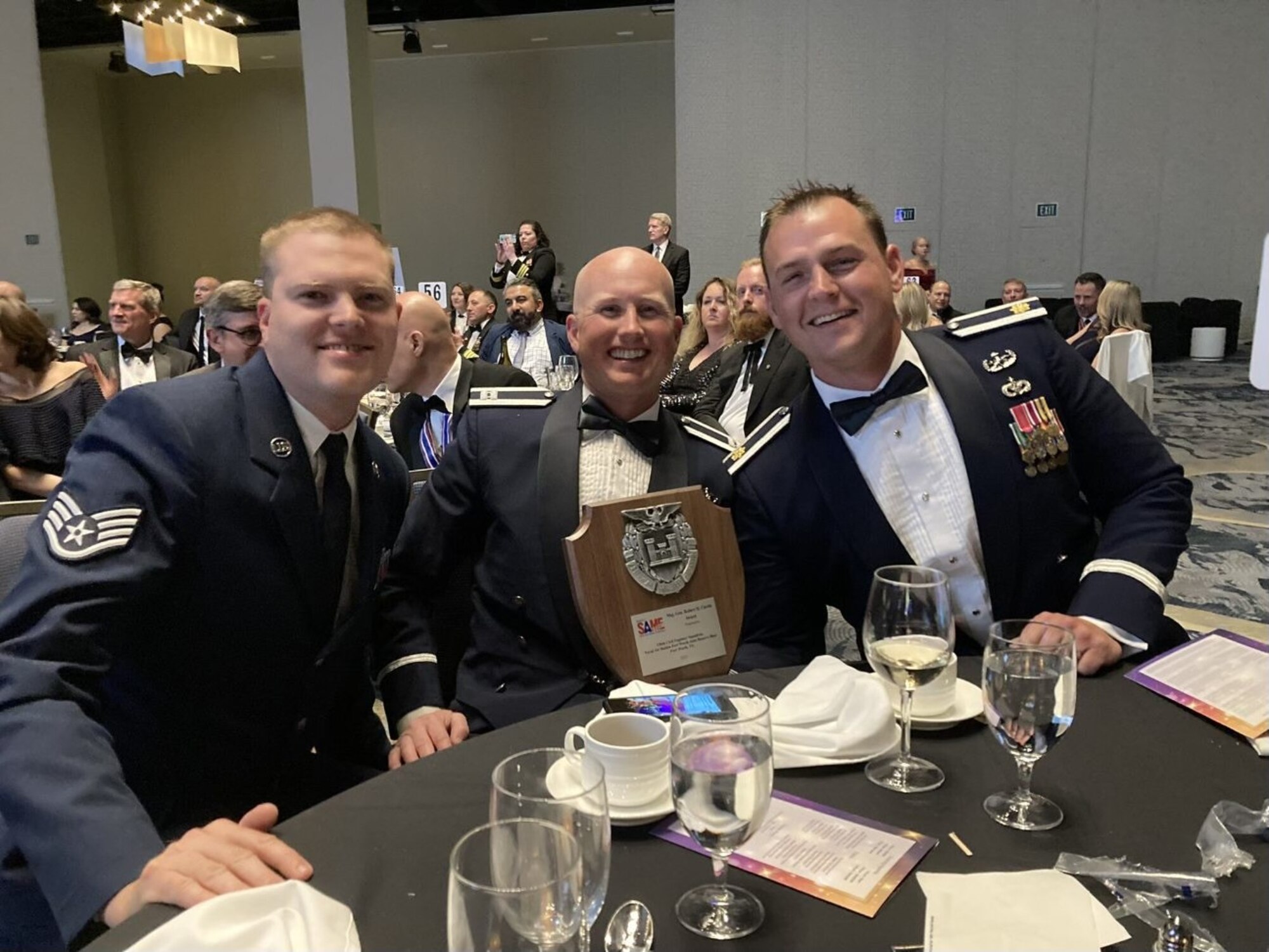 Airmen hold plaque.