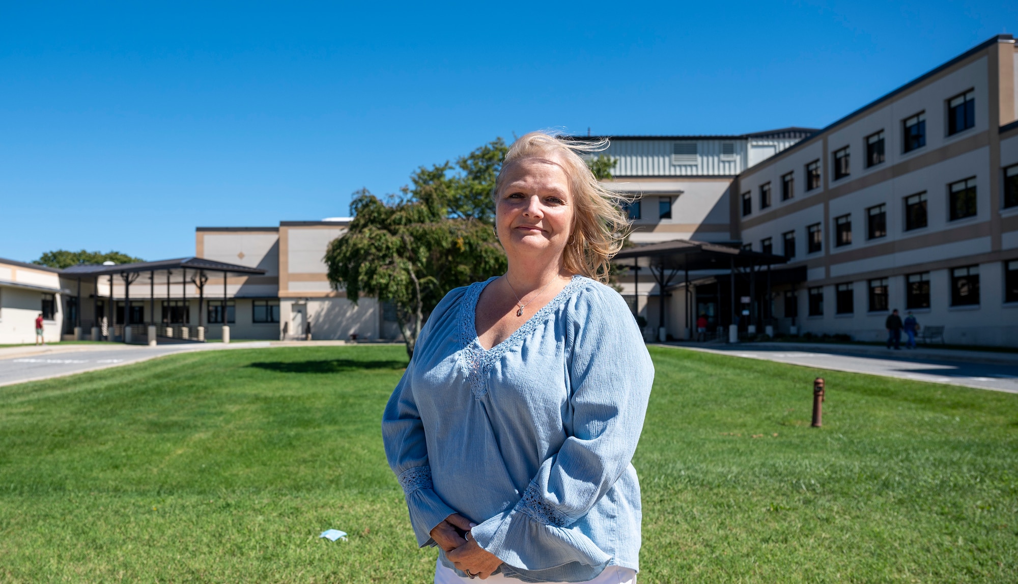 RaeAnn Rivera stands in front of the 436th Medical Group at Dover Air Force Base, Delaware, Sept. 23, 2022. Rivera was born at the hospital on Dover AFB in 1962 and recently retired after 35 years of service as the technical and laboratory supervisor at the 436th MDG. (U.S. Air Force photo by Senior Airman Cydney Lee)