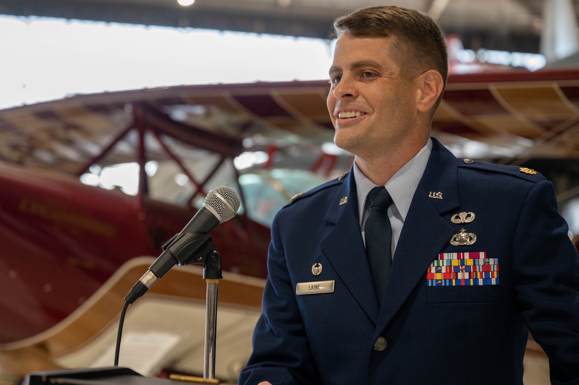 A U.S. Air Force Major speaks at a podium.