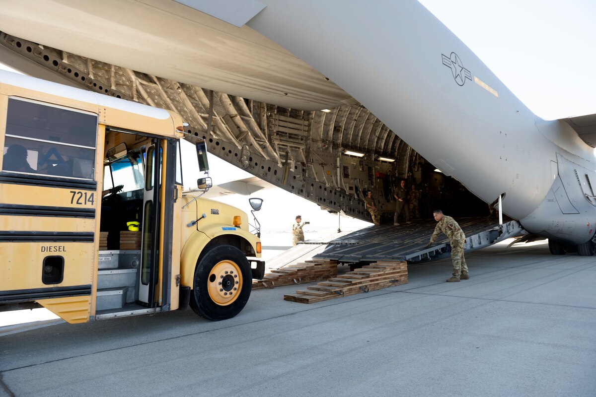 A school bus approaches a C-17 Globemaster III Sept. 23, 2022, at March Air Reserve Base, California. A Reserve aircrew from the 301st Airlift Squadron performed a three-day mission Sept. 23 – 25, to move humanitarian cargo to Haiti. Through the Denton Program, three school buses donated from San Diego Unified School District were transported from March ARB to Haiti. (U.S. Air Force photo by Senior Airman Jonathon Carnell)