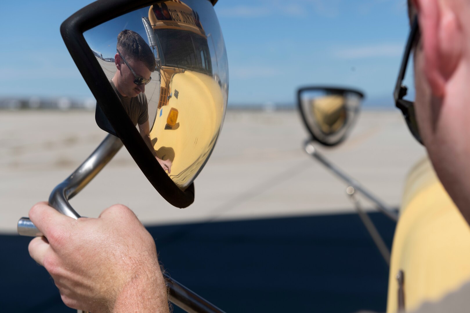 U.S. Air Force Senior Airman Jacob Grumich, 860th Aircraft Maintenance Squadron C-17 Globemaster III flying crew chief, alters the mirror on a school bus Sept. 23, 2022, at March Air Reserve Base, California. A Reserve aircrew from the 301st Airlift Squadron performed a three-day mission Sept. 23 – 25, to move humanitarian cargo to Haiti. Through the Denton Program, three school buses donated from San Diego Unified School District were transported from March ARB to Haiti. (U.S. Air Force photo by Senior Airman Jonathon Carnell)