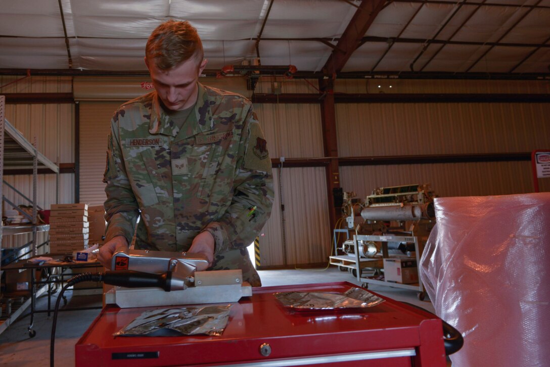 U.S. Air Force Senior Airman Jared Henderson, 36th Electronic Warfare Squadron technician, seals an ESD bag for the Reclamation of Electronic Attack Pods (REAP) program at Eglin Air Force Base, Florida, September 14, 2022. The REAP program is intended to sustain the service life of the AN/ALQ-184 ECM Pod legacy system by increasing the availability of parts for essential repairs across the U.S. Air Force. (U.S. Air Force photo by Staff Sgt. Ericka A. Woolever)