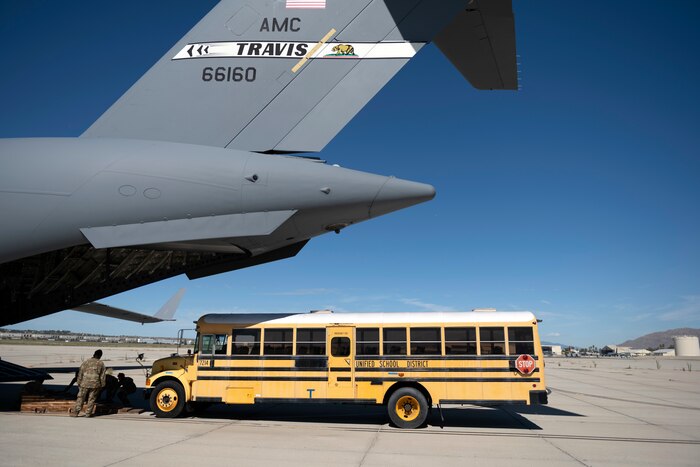 A school bus approaches a C-17 Globemaster III Sept. 23, 2022, at March Air Reserve Base, California. A Reserve aircrew from the 301st Airlift Squadron performed a three-day mission Sept. 23 – 25, to move humanitarian cargo to Haiti. Through the Denton Program, three school buses donated from San Diego Unified School District were transported from March ARB to Haiti. (U.S. Air Force photo by Senior Airman Jonathon Carnell)