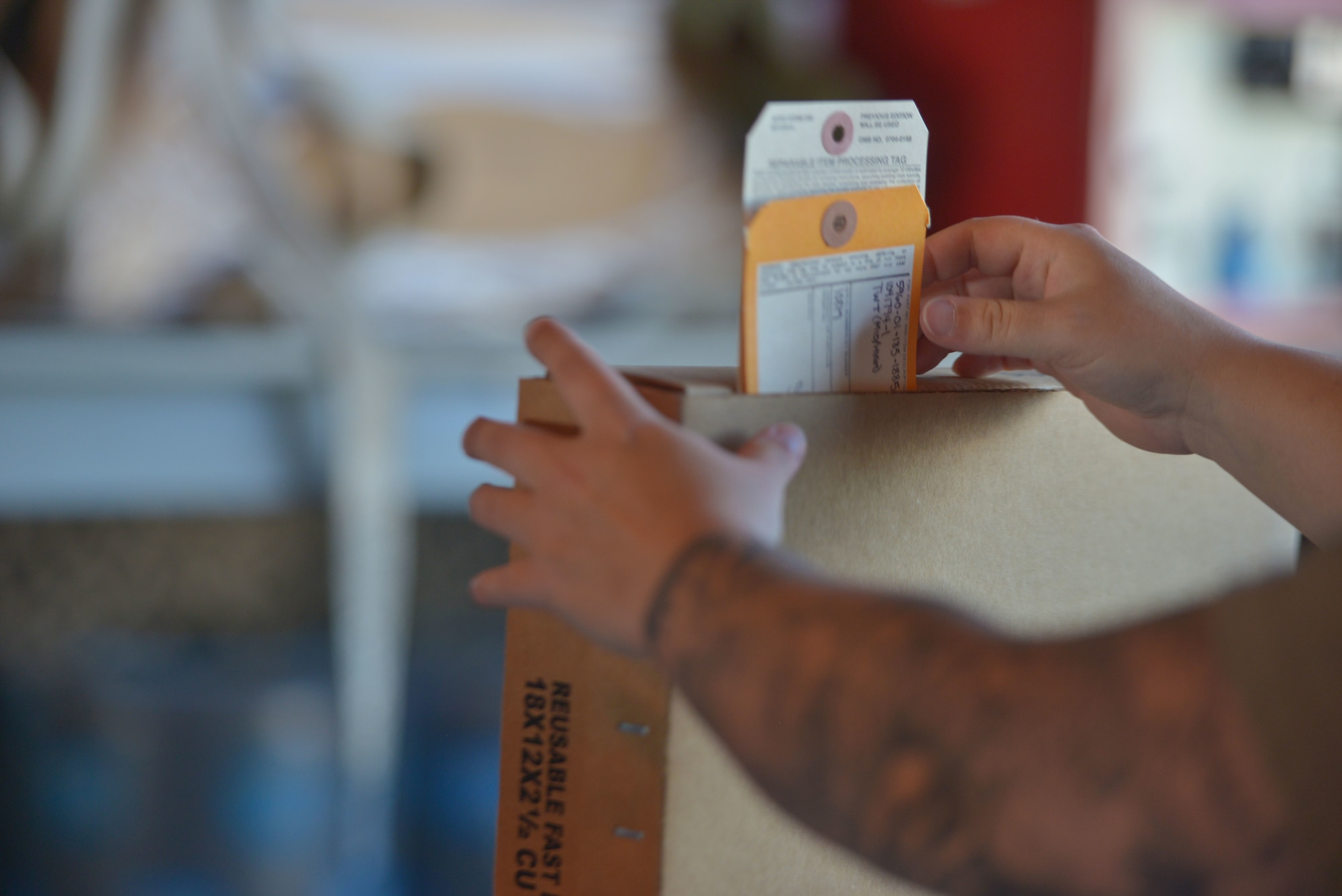 An Airman from the 36th Electronic Warfare Squadron slips a shipment card in a box at Eglin Air Force Base, Florida, September 14, 2022. Airmen from the 36th EWS started the Reclamation of Electronic Attack Pods (REAP) Program, which reclaims assets from stored AN/ALQ-184 Electronic Attack Pods by leveraging resources from the 350th Spectrum Warfare Wing to provide the receiving, diagnostic testing, recoupment, and shipment of assets back into the supply chain for future use. (U.S. Air Force photo by Staff Sgt. Ericka A. Woolever)