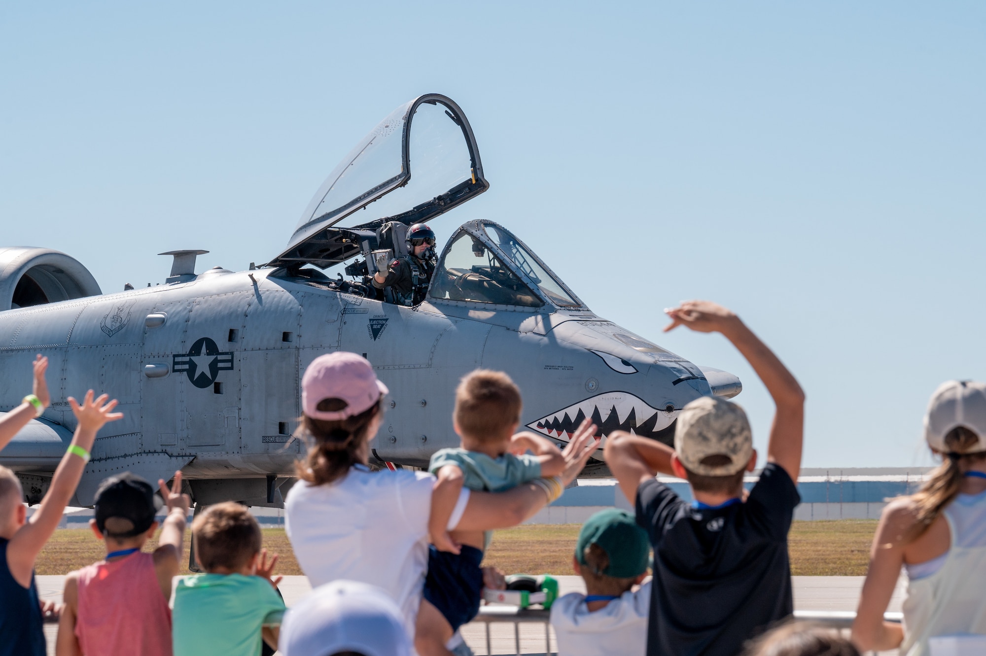 The children of local civic leaders wave to an A-10 Thunderbolt II as it passes them Sep. 25, 2022, at McConnell Air Force Base, Kansas.