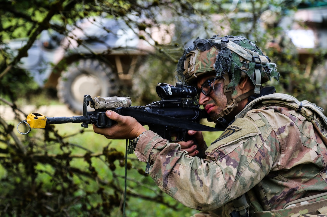 A soldier looks through the sight of a weapon.