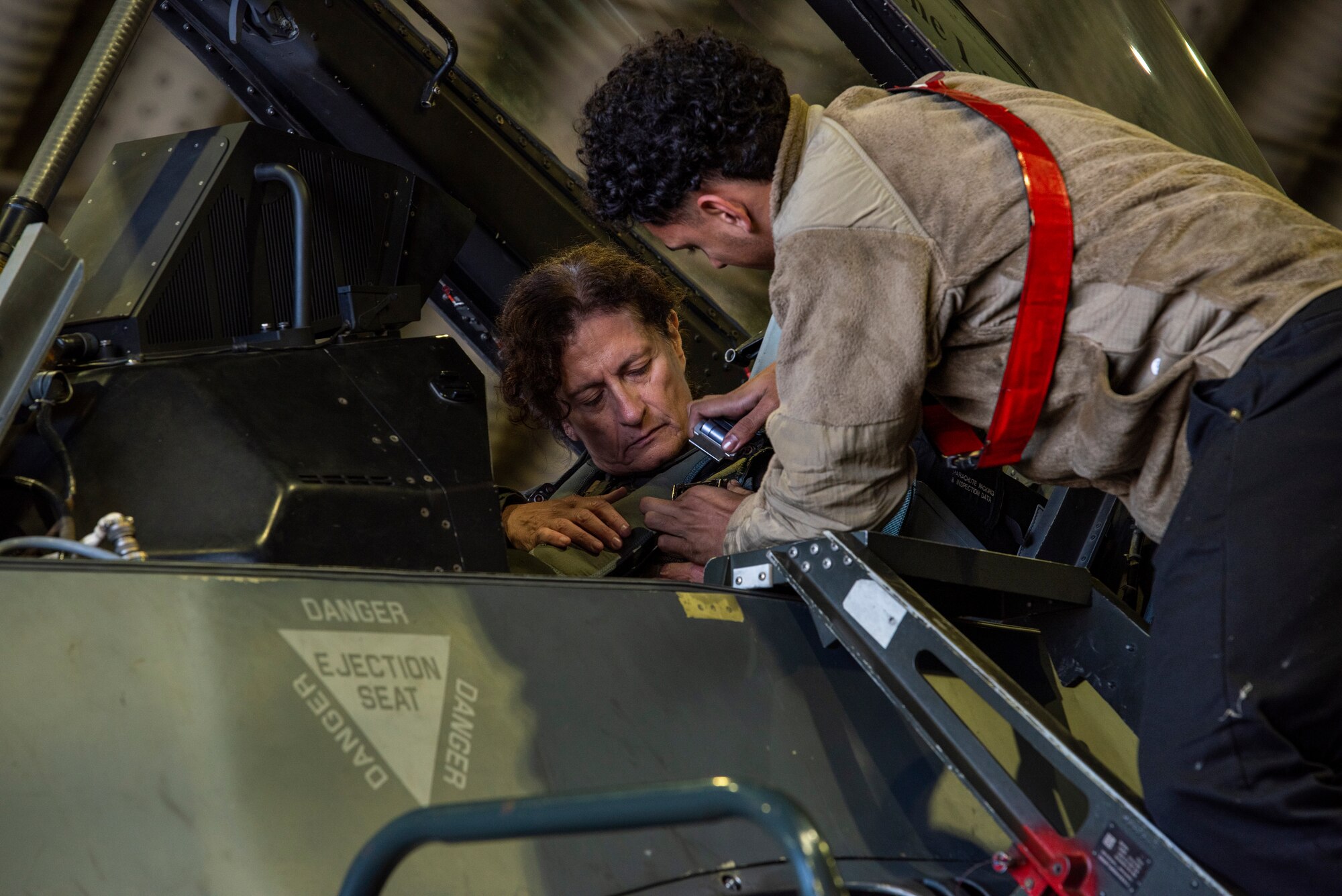 U.S. Air Force Senior Airman Mickael Ramos-Villarreal, 36th Fighter Generation Squadron crew chief secures the seatbelt of Dr. Victoria Coleman, USAF Chief Scientist before a familiarization flight in an F-16 Fighting Falcon at Osan Air Base, Republic of Korea, Sept. 23, 2022.