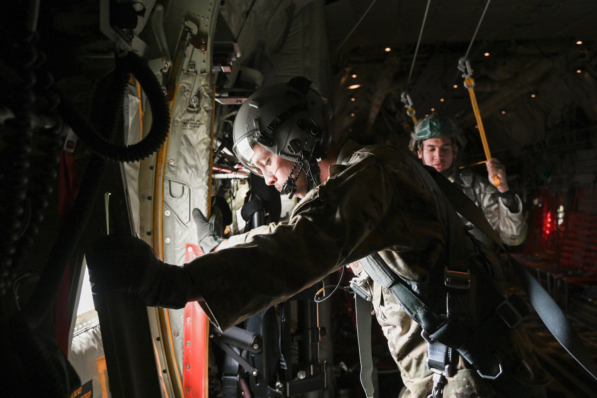 Airman waits to open the aircraft door for a static line exit.
