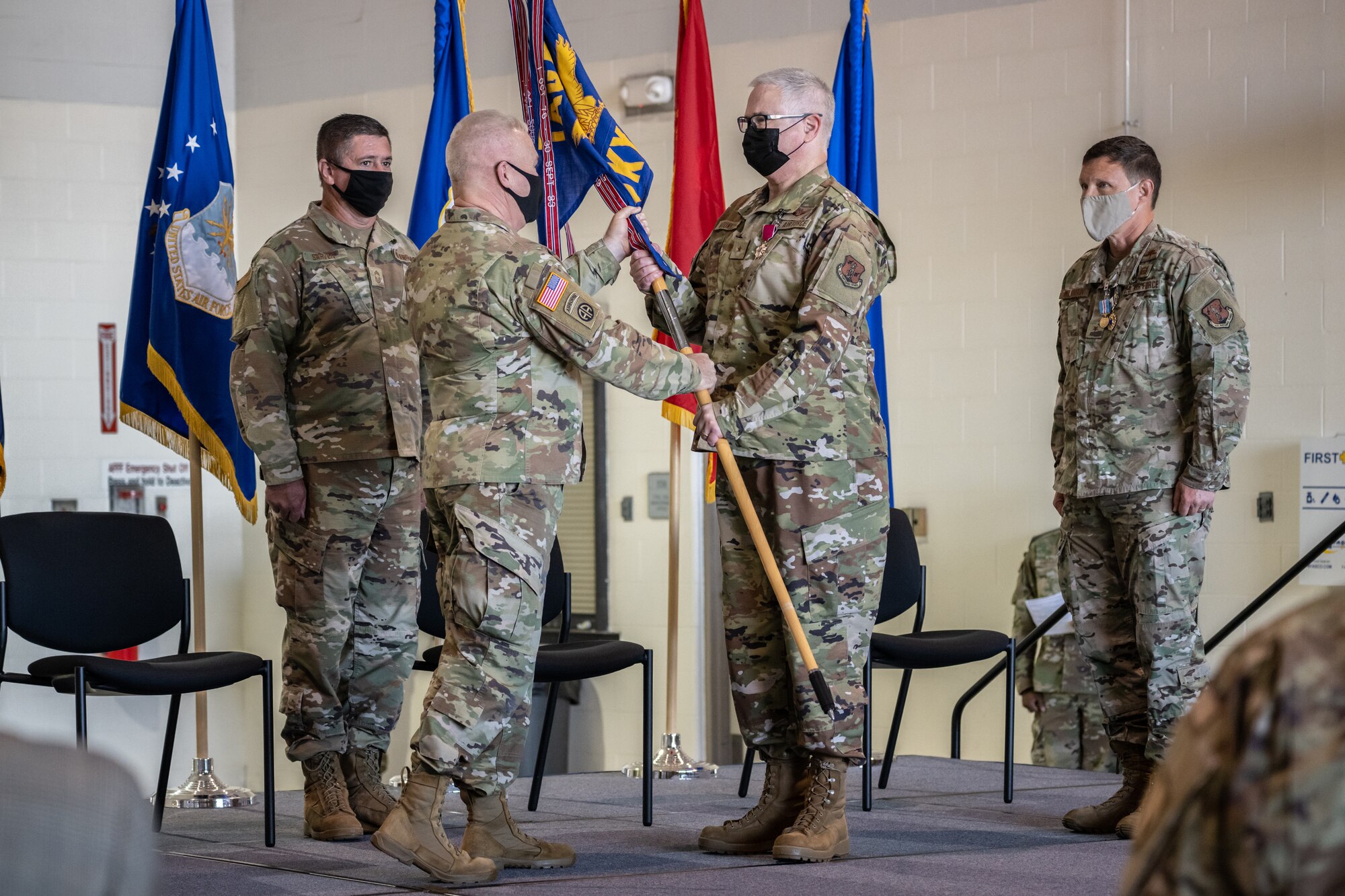 Brig. Gen. David J. Mounkes, center right, accepts the guidon of Headquarters, Kentucky Air National Guard, from Army Maj. Gen. Haldane B. Lamberton, center left, adjutant general of the Commonwealth of Kentucky, during a change-of-command ceremony at the Kentucky Air National Guard Base in Louisville, Ky., Aug. 13, 2022. Mounkes assumed command of the Kentucky Air Guard at the event, taking on the role of assistant adjutant general for Air from Brig. Gen. Jeffrey L. Wilkinson, far right, who is retiring. (U.S. Air National Guard photo by Dale Greer)