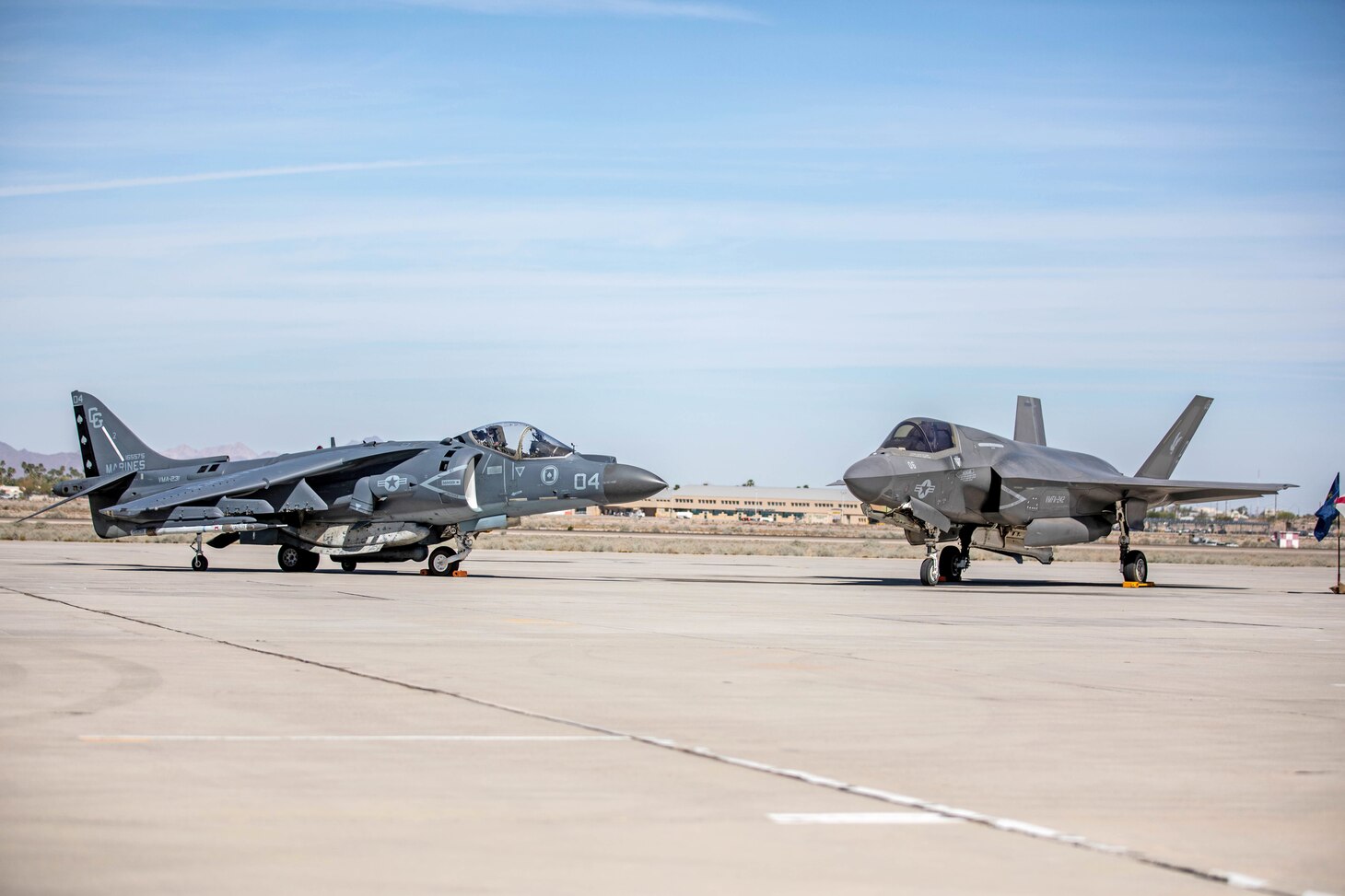 An AV-8B Harrier and an F-35B Lightning II are staged during the change of command and redesignation ceremony for Marine Fighter Attack Squadron (VMFA) 214 aboard Marine Corps Air Station Yuma, Arizona, March, 25, 2022. As part of the transition from the AV-8B Harrier to the F-35B Lightning II, Marine Attack Squadron 214 was re-designated as VMFA-214. The F-35B Lightning II is replacing the AV-8B Harrier to introduce unmatched capabilities to the Marine Corps. The F-35B Lightning II represents a leap forward in air dominance by providing the operational agility and tactical supremacy Marines need to provide expeditious and lethal support.