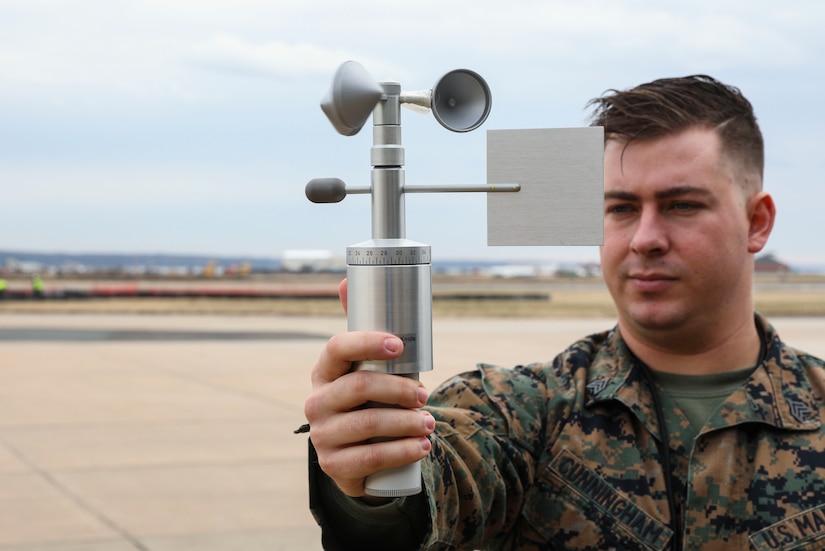 A man holds a metal device at arm’s length.