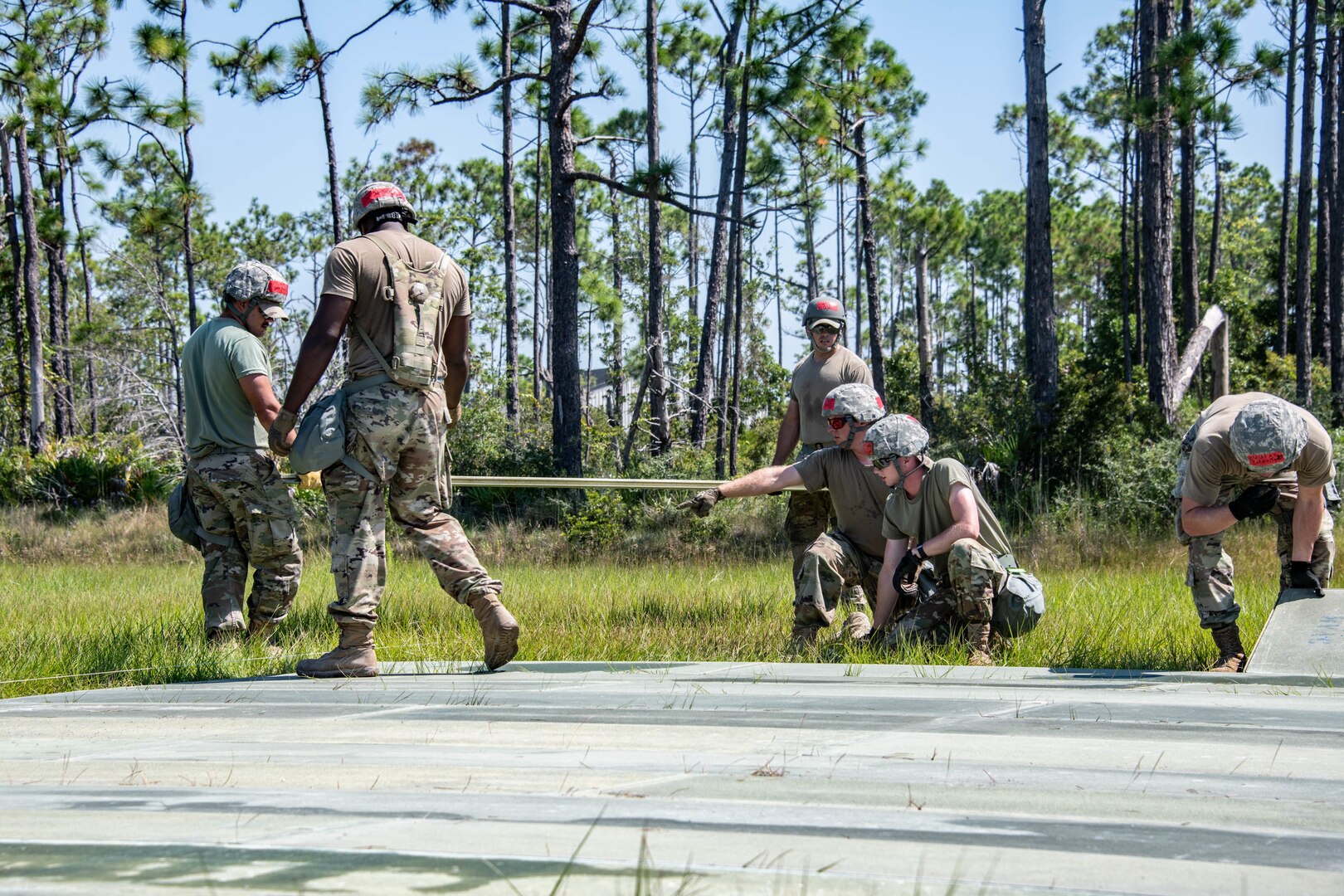 military personnel outside building a helicopter pad