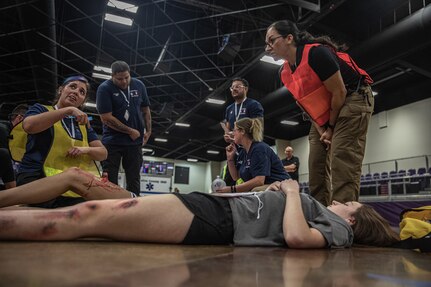 An emergency medical technician (far left) explains her evaluation of a simulated casualty during a Regional Emergency Medical Services System training event at the Choctaw Event Center in Durant, Oklahoma, September 21, 2022. A total of around 170 first responders participated in this annual training event. (Oklahoma National Guard Photo by Sgt. Reece Heck)