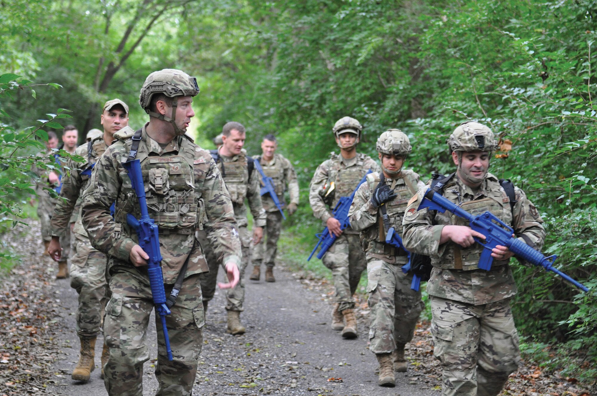 Approximately 20 members of the 445th Security Forces Squadron execute a ruck march with gear weighing 20-30 lbs for 9.11 miles near the perimeter of the base in remembrance of Patriot Day, Sept. 11, 2022, at Wright-Patterson Air Force Base, Ohio. A ruck march is a weighted march over terrain with all necessary military equipment to accomplish an objective.