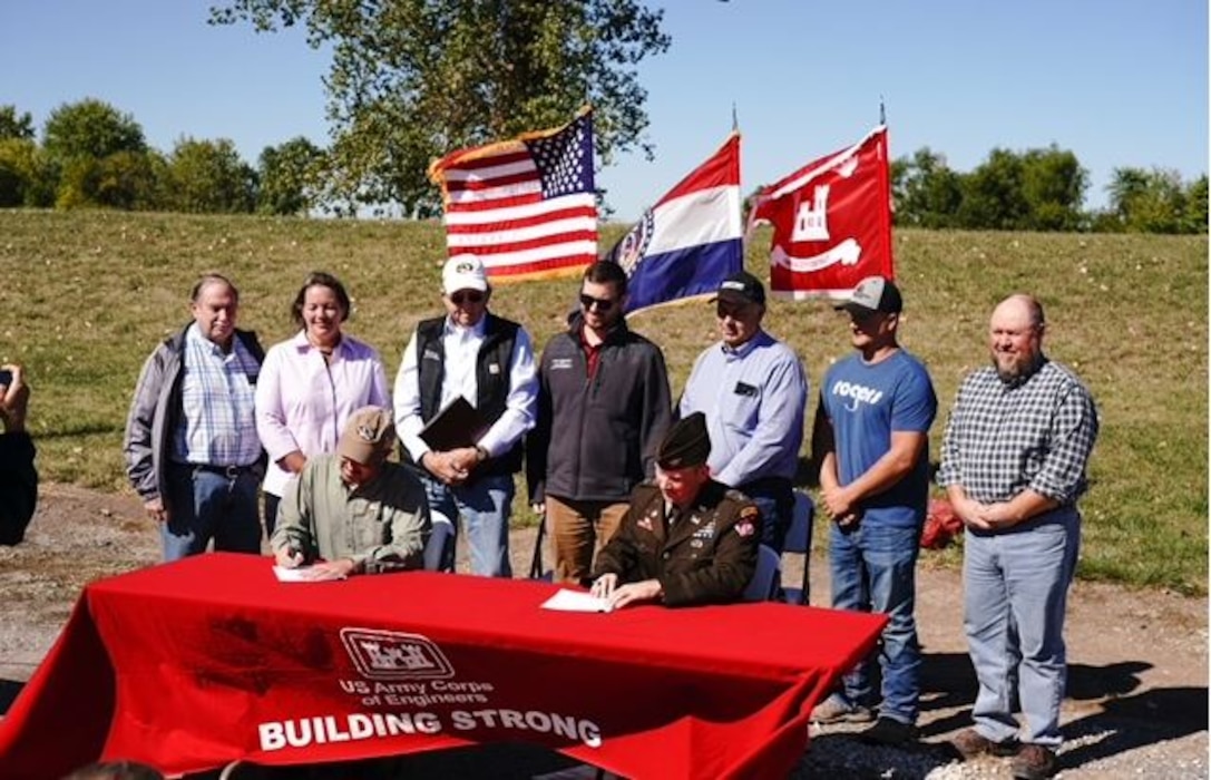 Dru Buntin (left), Missouri Department of Natural Resources director, and Col. Travis Rayfield (right), U.S. Army Corps of Engineers, Kansas City District commander, sign a Feasibility Cost Share Agreement for a feasibility study on the Brunswick / Left Bank, River Mile 246 area of the BLANK while surrounded by partners on Sept. 28, 2022, in Brunswick, Missouri. Photo by Ben Nickelson, Missouri Department of Natural Resources.