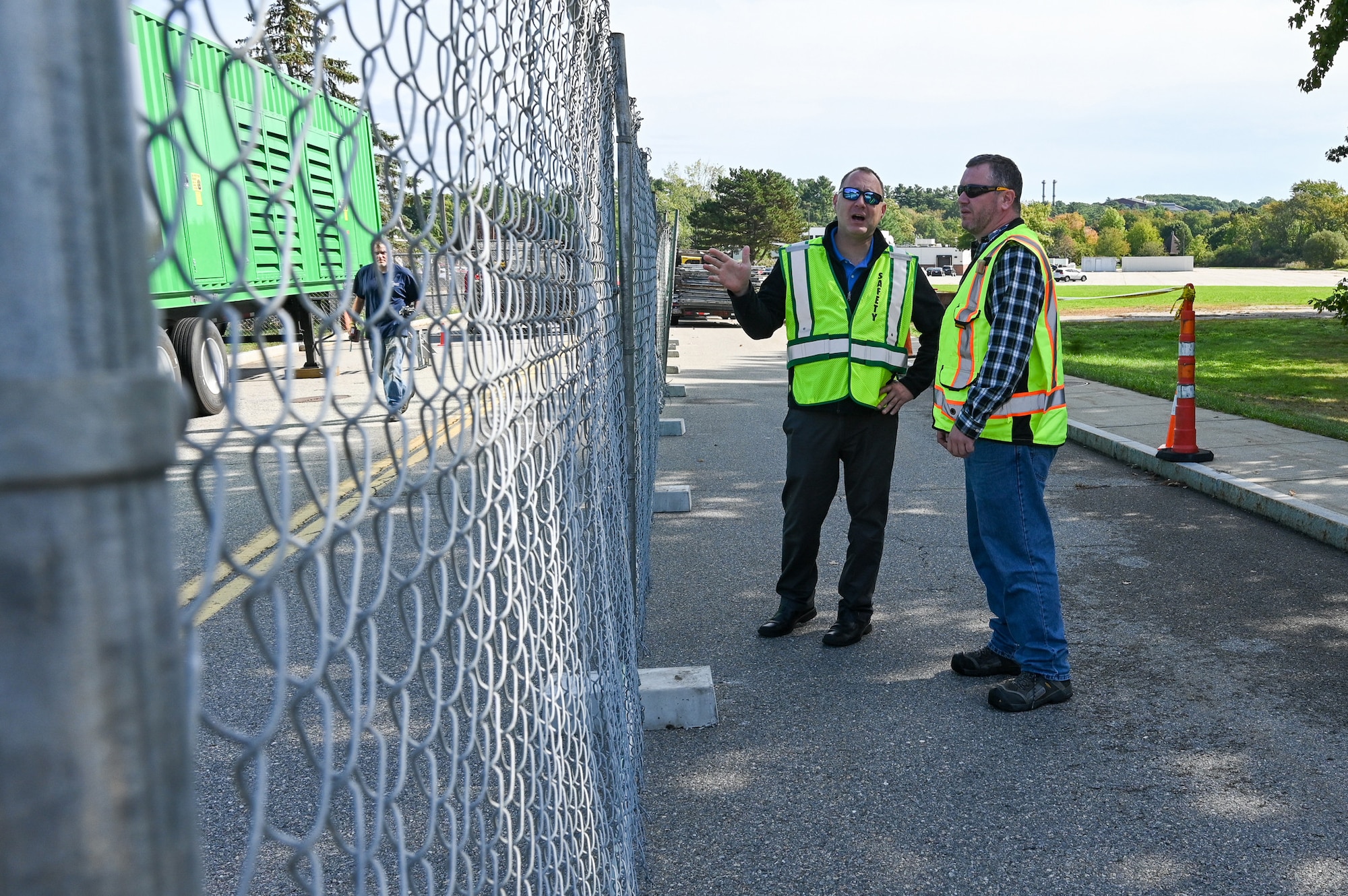 Image of two men talking near a work site