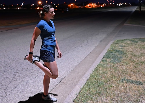 U.S. Air Force Capt. Molly Dunkelberger, 17th Medical Group aerospace nurse practitioner, stretches before a run at Goodfellow Air Force Base, Texas June 28, 2022. Dunkelberger's mission is to ensure that her patients in the 17th Training Wing are fit to fight as they accelerate forward, venturing ever into danger. (U.S. Air Force photo by 2nd Lt. Steve Garrett)