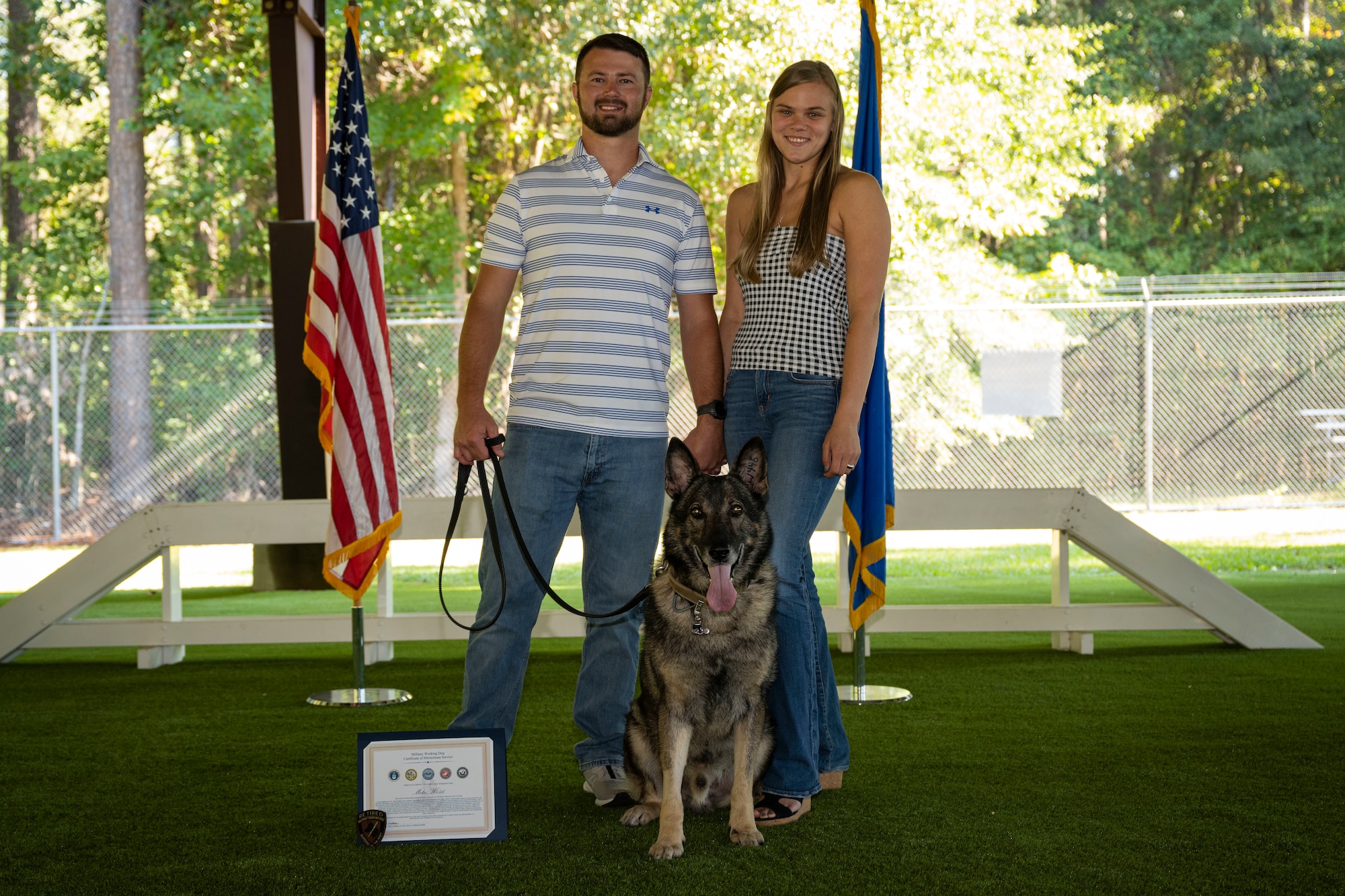 MWD Miko, Nick Armstrong, Miko’s former handler, and Megan McKinney, Armstrong’s fiancé post for a photo at Seymour Johnson Air Force Base, North Carolina, Sept. 26, 2022. Armstrong took ownership of Miko after his retirement. (U.S. Air Force photo by Senior Airman David Lynn)