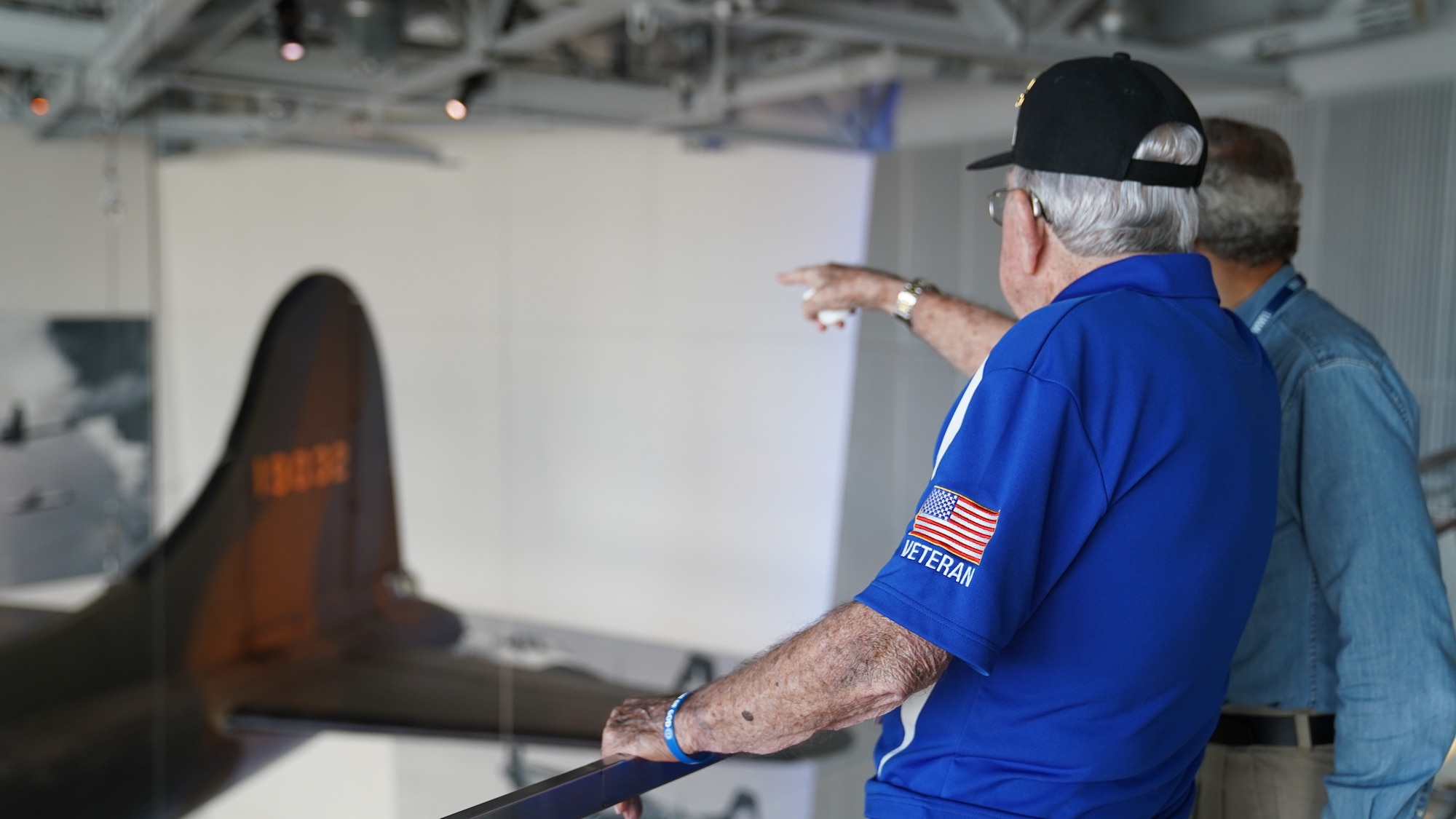 Retired U.S. Army Air Forces Chief Master Sgt. Mel Jenner, 452nd Bomber Group radio operator, points out his former position as an aerial gunner to Jack Gross, National World War II Museum docent, at the National WWII Museum, New Orleans, Louisiana, Sept. 14, 2022. Jenner began his 26 year military career by training as a radio operator at what was then known as Keesler Army Airfield. (U.S. Air Force photo by Airman 1st Class Elizabeth Davis)