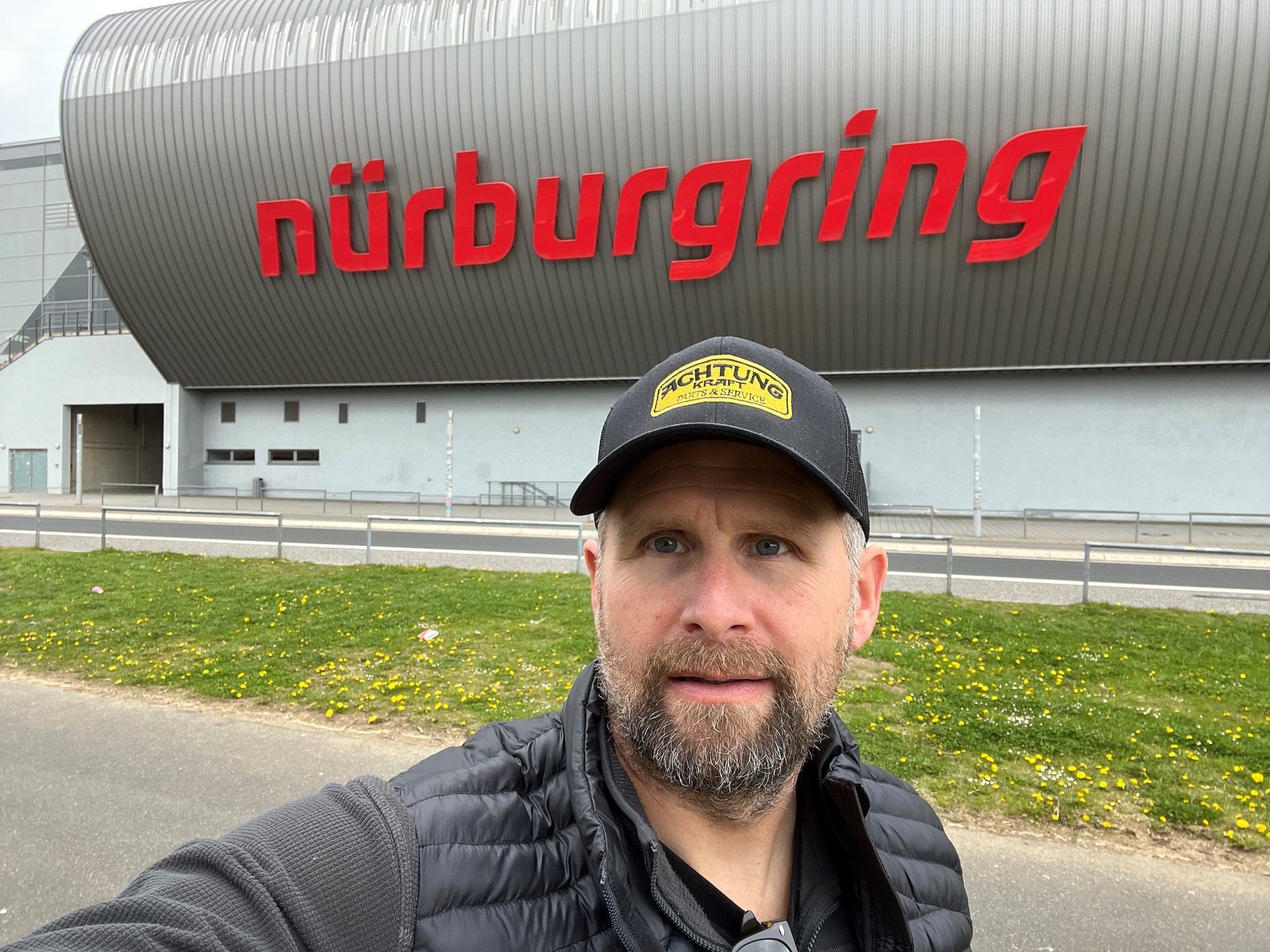 A man poses for a photo in front of a building.