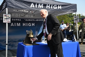 Secretary of the Air Force Frank Kendall rings a small bell.