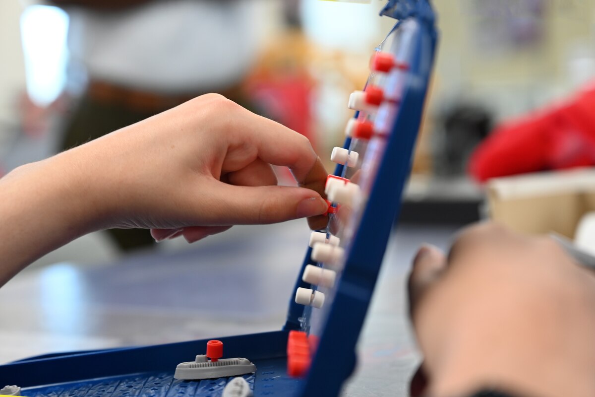 U.S. Air Force Airman 1st Class Lauren Arduser, 311th Training Squadron Russian language analyst, pushes a peg into the map, marking a ‘hit’ to her opponent’s battleship, at the St. Louis VA Healthcare System-Jefferson Barracks, Missouri, August 17, 2022. Arduser suffered an interrupted spinal cord injury, meaning her crushed C6 and broken C7 vertebrae required life-saving surgery. Each day during her rehabilitation, Arduser exceeded all expectations for her recovery. (U.S. Air Force photo by Senior Airman Abbey Rieves)